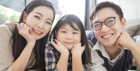 Wall Mural - Portrait of happy asian family spending time together in living room. family and home concept