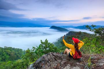 The girl in yellow  jacket touring on the mountain, Phu-pha-nong, Loei province, Thailand.