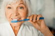© Yakobchuk Olena - Lovely old lady brushing teeth in the morning