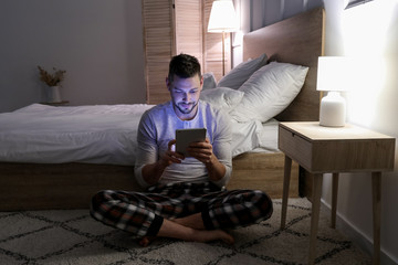 Wall Mural - Man with tablet PC in bedroom at night