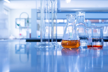 Wall Mural - glass flask beaker and cylinder in chemistry blue laboratory background