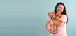 happy asia woman holding cute pomeranian dog, isolated on blue background in studio With copy space.
