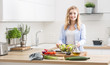 © weyo - Young happy blonde girl preparing healthy salad in home kitchen