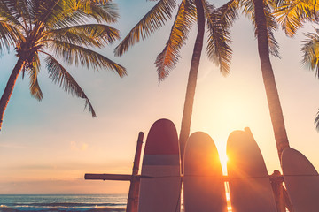 Surfboard and palm tree on beach background.