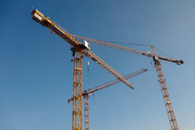 Luffing Jib Tower Crane At Large Scale Construction Site Over Blue Sky