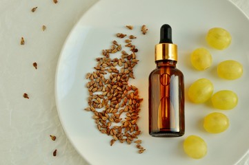 Wall Mural - Grape seed oil in a bottle on a plate close up