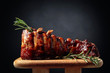 Grilled pork ribs with rosemary on a wooden board.