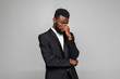 © F8  \ Suport Ukraine - Young handsome African businessman wearing suit sad or bad feel against gray background