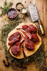 raw sliced venison ribs and meat cleaver on wooden background