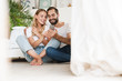 © Drobot Dean - Cheerful beautiful young couple sitting at the couch