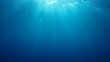 Underwater blue background in ocean with sunbeams