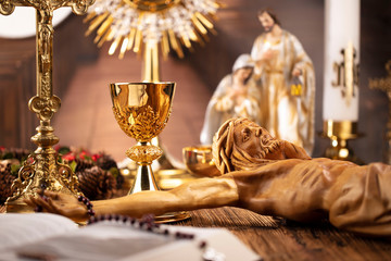 catholic concept background. the cross, monstrance, jesus figure, holy bible and golden chalice on t