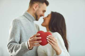 Wall Mural - Valentine's day. Loving couple with hearts in hand cuddle in the room.