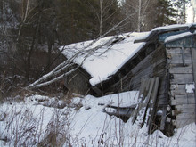      Old Ruined Wooden House In The Forest. Abandoned Building In The Mountains In Winter. Decrepit Dilapidated House. Rustic Grunge Background. A Collapsed Shack In The Snow.   