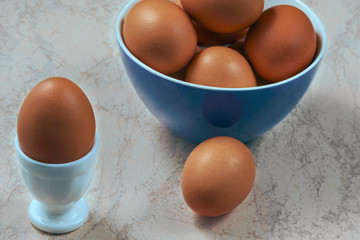 fresh chicken eggs in ceramic cups on a wooden background. Healthy eating concept