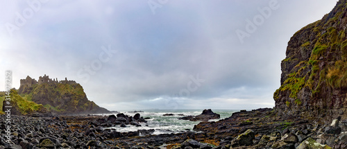 Ruined medieval Dunluce Castle on the cliff dramatic sky Poster Mural XXL