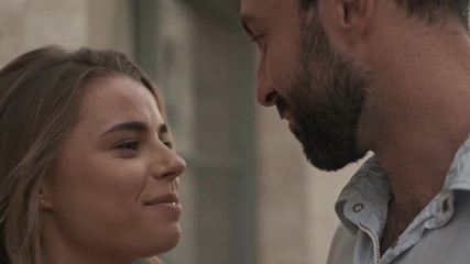 Canvas Print - A close-up view of a lovely couple are looking at each other while standing at the city street