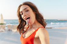 Photo Of Young Funny Woman Sticking Out Her Tongue And Taking Selfie