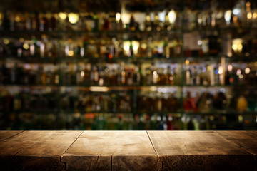 background Image of wooden table in front of abstract blurred restaurant lights