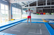 Fitness, fun, leisure and sport activity concept - Handsome happy man jumping on a trampoline indoors