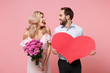 © ViDi Studio - Laughing young couple two guy girl in party outfit celebrating posing isolated on pink background. Valentine's Day Women's Day birthday holiday concept. Hold empty blank red heart bouquet of flowers.