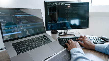 programmer typing code on desktop computer, developing programming and coding technologies concept.