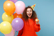 © ViDi Studio - Surprised young african american girl in casual orange knitted clothes, birthday hat isolated on pastel blue background. Holiday party concept. Celebrating hold colorful air balloons cake with candle.
