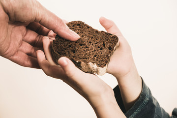 two beggar hands palms with cheap bread. poor children and people donations volunteers concept.