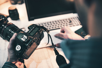 photographer hand camera and computer on desk