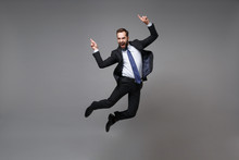 Happy Young Business Man In Classic Black Suit Shirt Tie Posing Isolated On Grey Background. Achievement Career Wealth Business Concept. Mock Up Copy Space. Jumping, Point Index Fingers Up, Screaming.