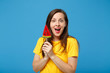 © ViDi Studio - Excited cheerful young brunette woman girl in yellow t-shirt posing isolated on bright blue wall background studio portrait. People lifestyle concept. Mock up copy space. Holding watermelon lollipop.