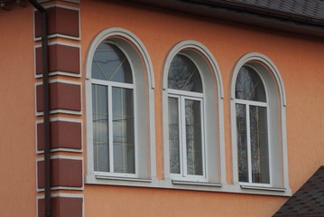 Canvas Print - three large white windows on the brown concrete wall of a private house on the street