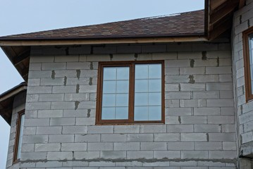 Canvas Print - one large window on the gray brick wall of the house under a tiled roof