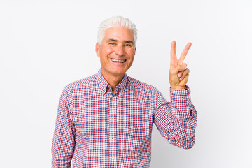 Senior caucasian man isolated showing victory sign and smiling broadly.