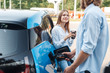 Traveling. Young couple traveling by electric car stopping at charging station boyfriend plugging in cable talking with girlfriend drinking hot coffee joyful