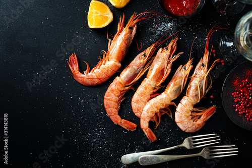 Fotomural Uncooked giant shrimps on dark table
