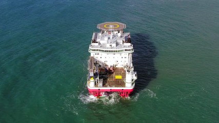 Wall Mural - Large Platform supply ship with Helipad and two large cranes, anchored at Sea, Aerial view.