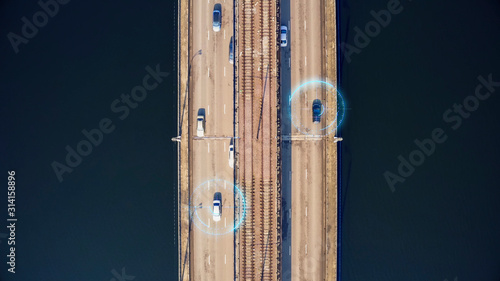 Autonomous self-driving cars on city bridge, aerial top view. Driverless autos and artificial intelligence system with sensors wireless communication. Future transportation technology concept.