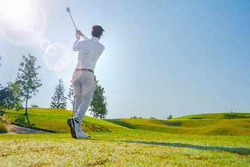 Asian golfers are playing golf on the golf course.Golfers playing golf.