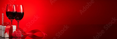 Cuadros en Lienzo Gift box, red hearts, glasses with wine on red background
