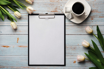 Wall Mural - bouquet of white tulips with an empty paper tablet and a Cup of coffee on a wooden table
