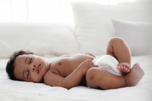 Portrait Of African American Baby Girl Sleeping On White Bed