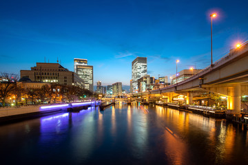 Wall Mural - Osaka skyscraper building with Tosahori river in Nakanoshima business district at night in Osaka, Japan. Japan tourism, modern city life, or business finance and economy concept