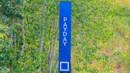 Wall Mural - Panorama Payday sign against grasses and trees in Park City ski resort at off season