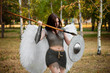 A warrior girl in chain mail with steel bracers and greaves and wings behind her back, holding a spear and a shield.