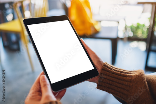 Cuadros en Lienzo Mockup image of a woman sitting and holding black tablet pc with blank white des