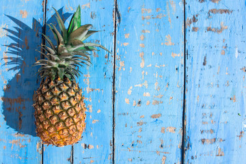 Wall Mural - fresh pineapples and on a wooden background