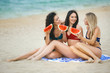 © olenachukhil - Attractive women on the beach having fun. Girls on the vacation. Girls party. Young ladies tanning.