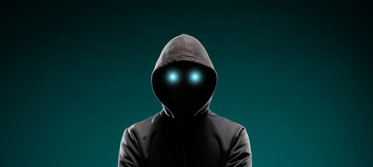 Wall Mural - Computer hacker in hoodie. Obscured dark face. Data thief, internet fraud, darknet and cyber security concept.