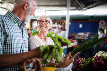 Wall Mural - Only the best fruits and vegetables. Beautiful mature couple buying fresh food on market